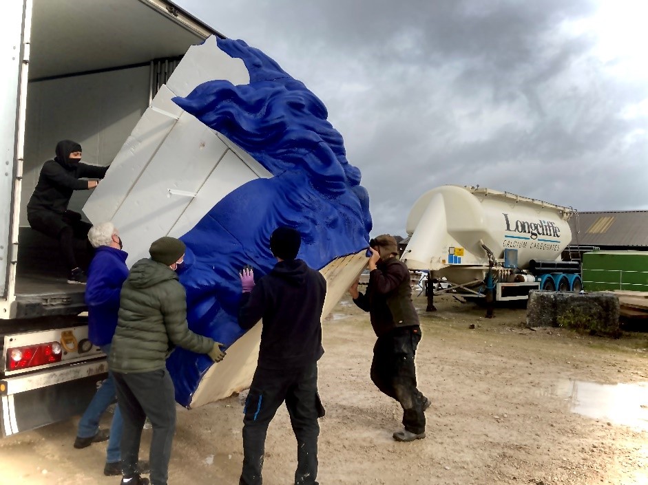 The Buxton Opera House crew lifting a giant blue head and moving it to a container at Longcliffe Quarries